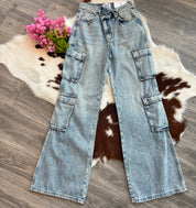 Light blue jeans on a wooden floor with a cowhide rug and pink flowers.
