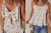 A woman wears a white ribbed tank top with delicate pink floral prints and a large bow detail on the back, styled with blue jeans and a white crossbody bag.