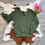 Green sweater on a cowhide rug with pink flowers