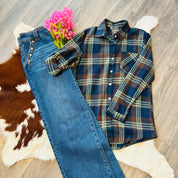 Plaid shirt and jeans on a wooden floor with a cowhide rug