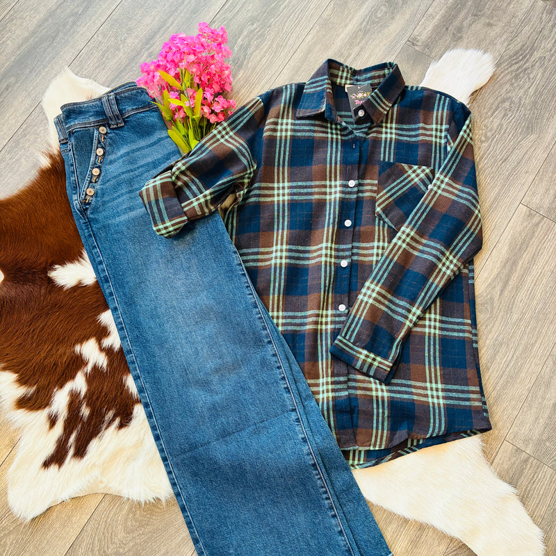 Plaid shirt and jeans on a wooden floor with a cowhide rug