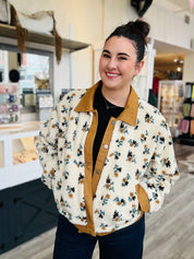 Woman wearing a floral jacket with a brown collar in a store setting