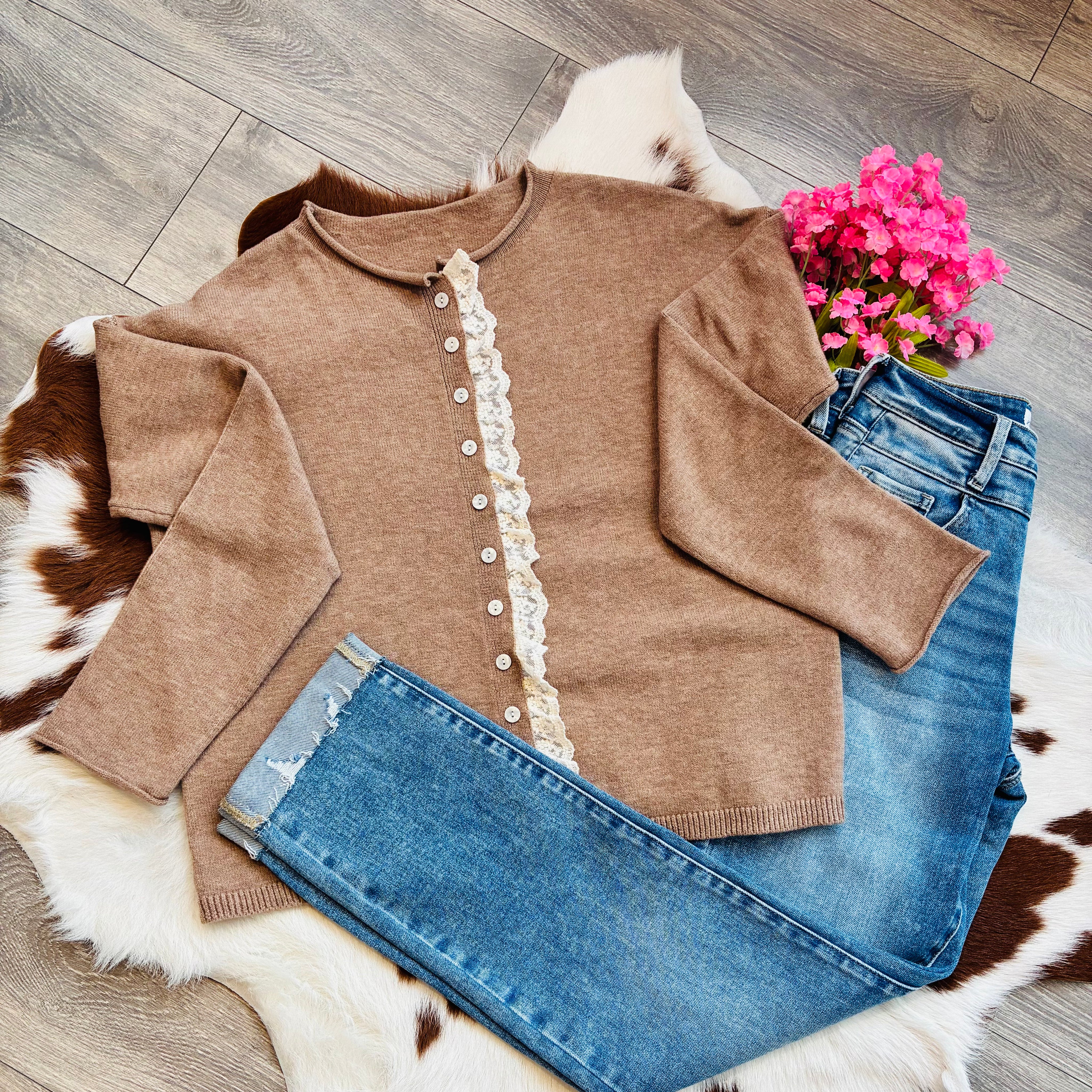 rown lace trim button front cardigan styled flat lay with cuffed distressed jeans and pink flowers on cowhide rug background