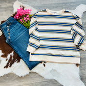 Striped sweater and jeans on a fur surface with pink flowers.