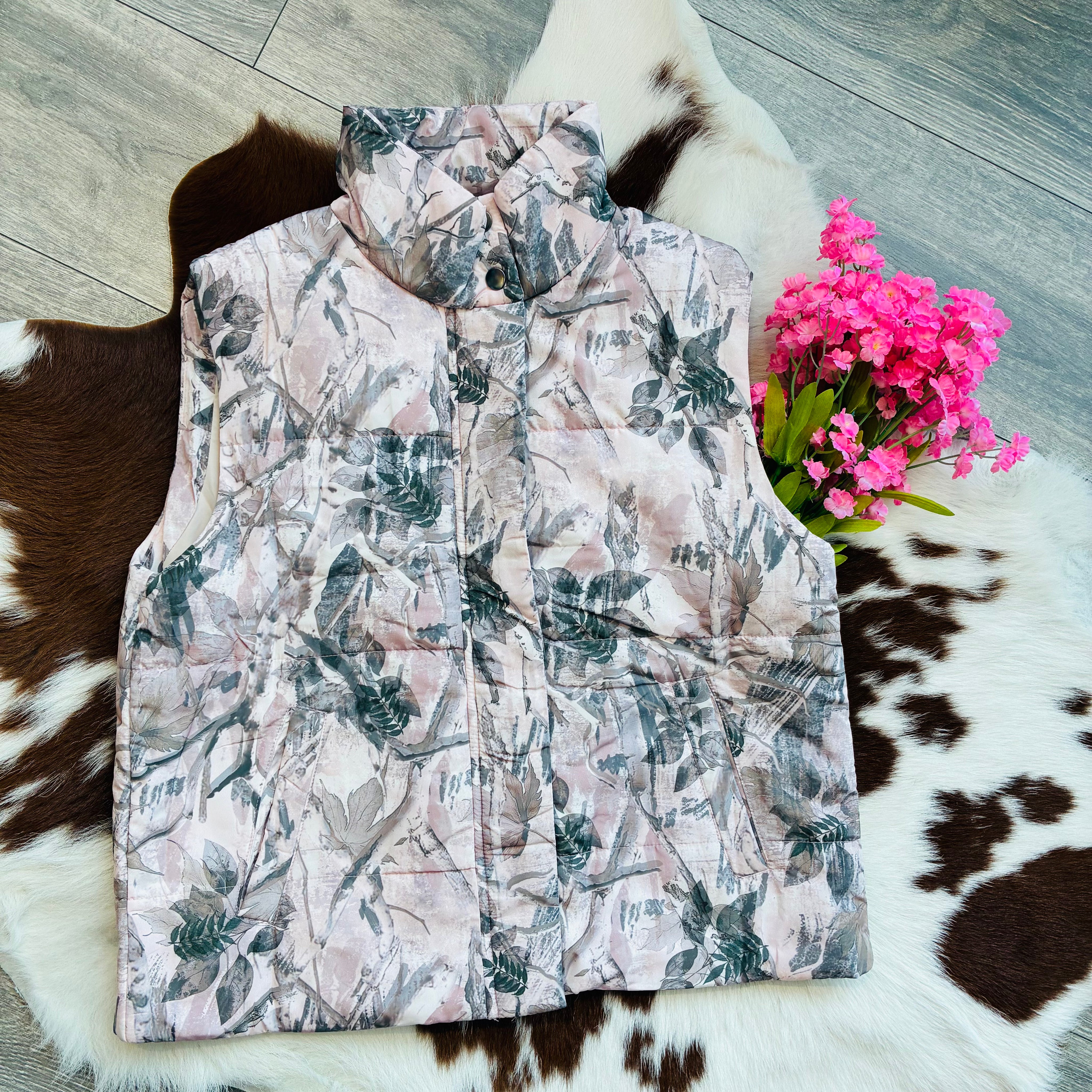 Floral patterned vest on a cowhide rug with pink flowers