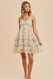 Floral mini dress with lace trim insets, adjustable twill tape tie straps, smocked back, and a hidden side zipper. Featuring a breathable silk-like fabric and a romantic garden-inspired design.