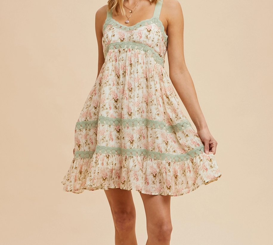 Floral mini dress with lace trim insets, adjustable twill tape tie straps, smocked back, and a hidden side zipper. Featuring a breathable silk-like fabric and a romantic garden-inspired design.