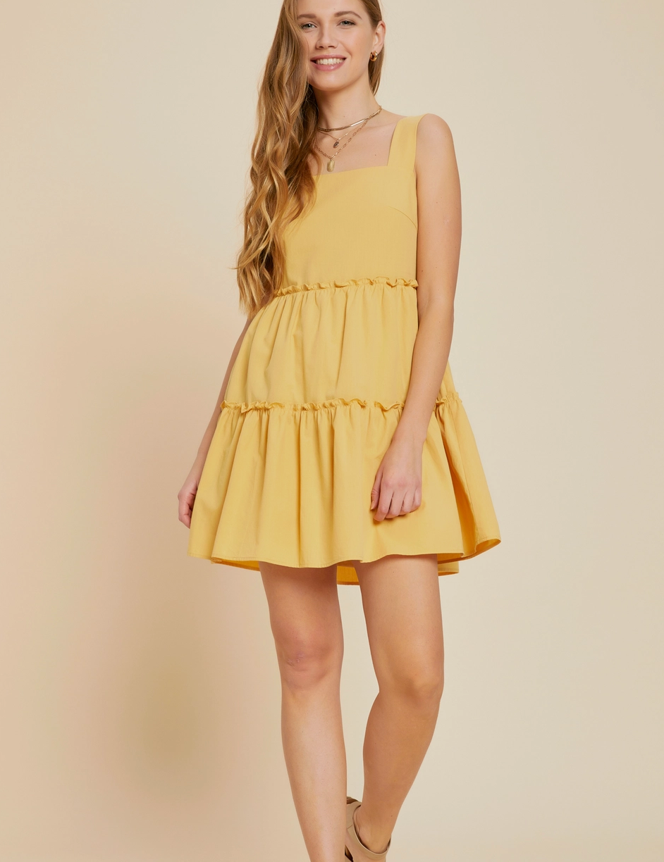 Yellow tiered mini dress with a square neckline, ruffle skirt, and a relaxed fit, made from 100% cotton for a breathable and lightweight feel, perfect for spring and summer fashion.