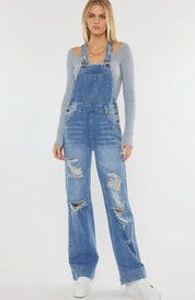 Women’s wide-leg denim overalls in medium stone wash with a relaxed fit, square neckline, adjustable shoulder straps, and front pocket details. Made from 100% cotton rigid, non-stretch denim for a vintage-inspired look. Perfect for casual and trendy outfits.