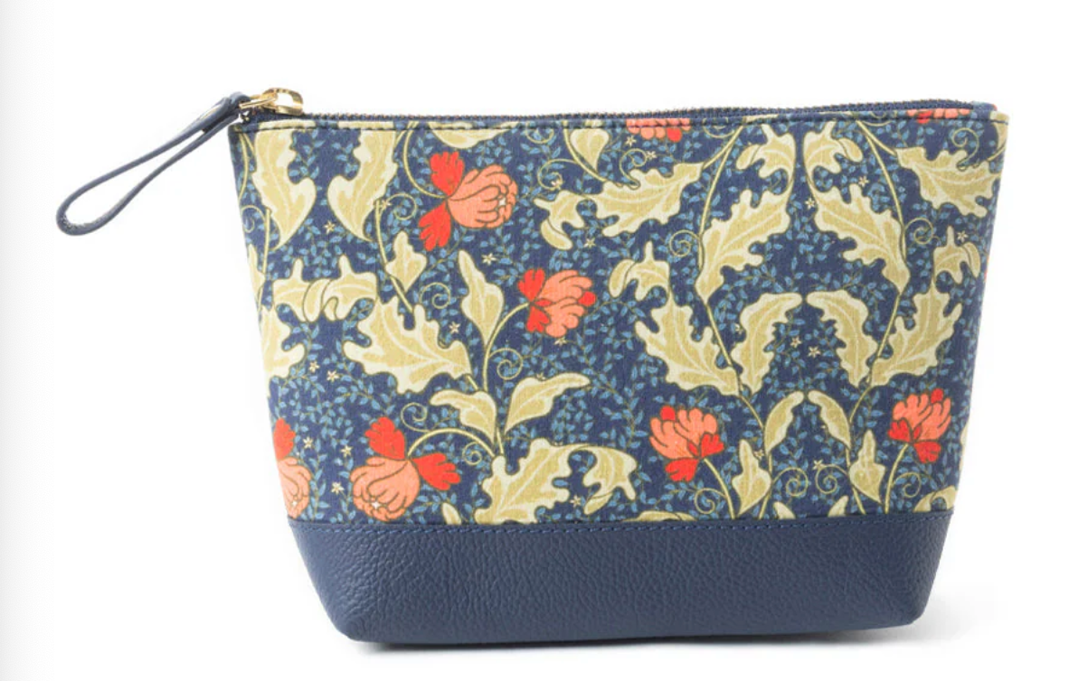 Navy clutch bag with red and coral floral print, gold leaves, and faux leather navy base with wristlet strap.