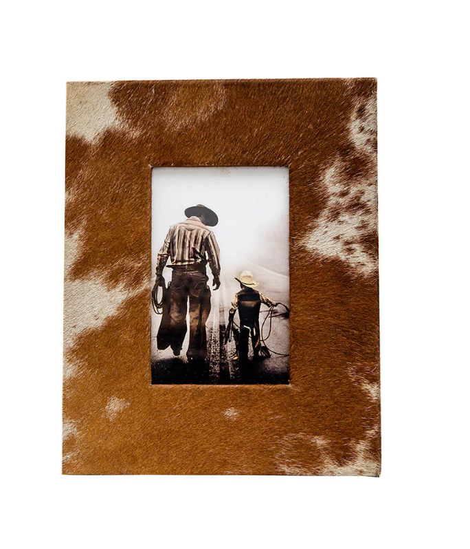 Rustic cowhide photo frame with a brown and white hair-on-hide texture, holding a 4x6 western-themed photo.