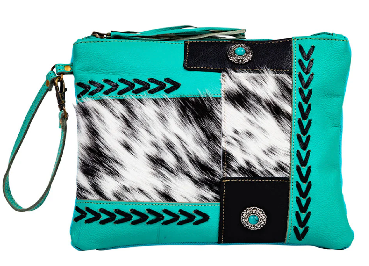 Turquoise leather wristlet pouch with black-and-white cowhide, whipstitch accents, arrow embroidery, and silver concho turquoise studs.
