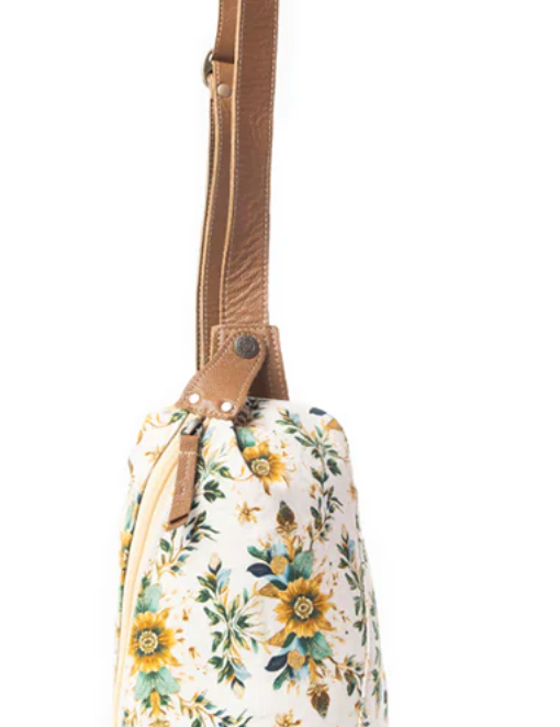 Floral fanny pack bag with yellow and green blossoms, cream canvas body, and tan faux leather adjustable strap.