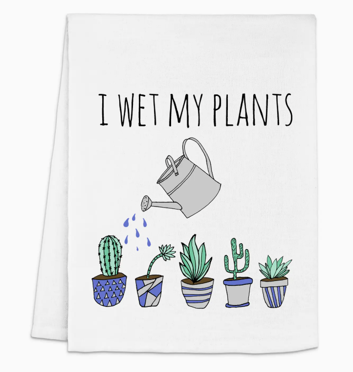 "I Wet My Plants" tea towel featuring a watering can and various potted plants, designed for home and kitchen use.