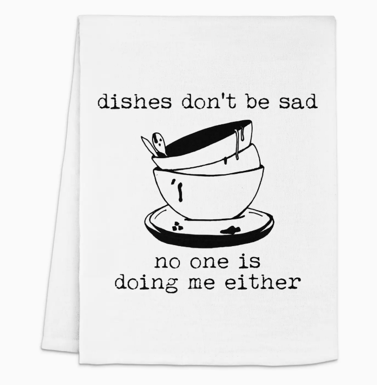 A white towel featuring the phrase "Dishes don't be sad, no one is doing me either" in black text, accompanied by an illustration of stacked bowls.Get yours today and let your towel bring a smile to your kitchen! 🥳✨