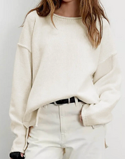 Cozy cream oversized sweater on a model, styled with high-waisted pants and a belt.