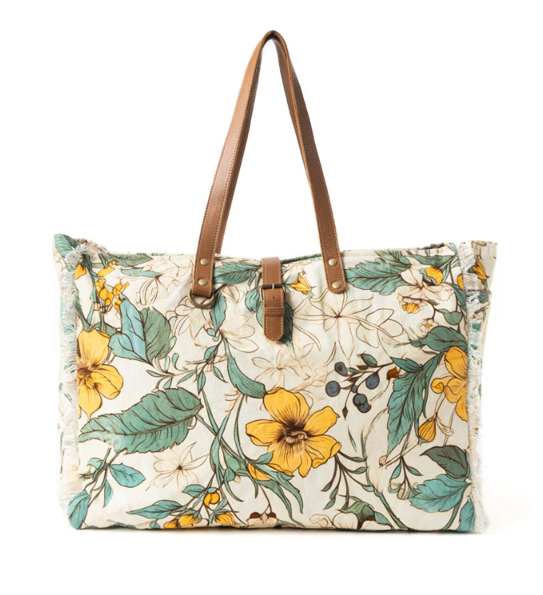 Floral-patterned tote bag with brown straps on a white background