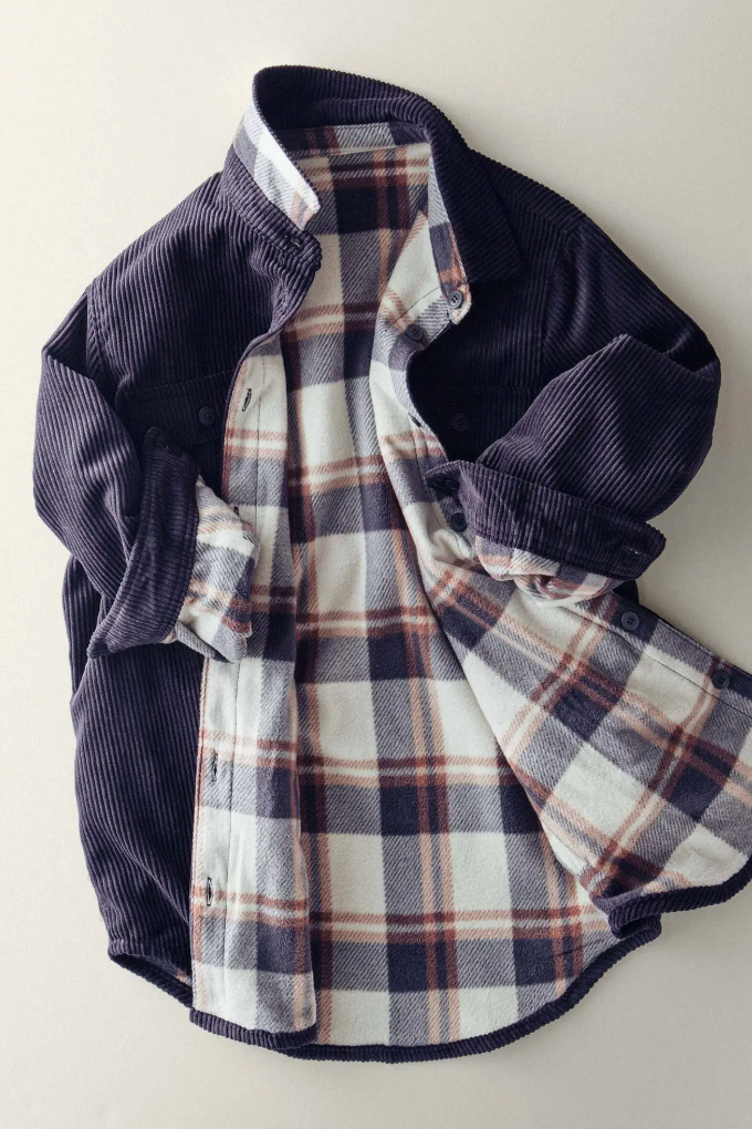 Plaid shirt with dark blue collar and sleeves on a light background