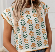 Model wearing a floral print cropped knit top with yellow and green flower designs, showcasing a trendy and casual spring/summer look.