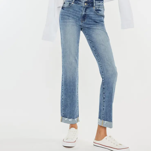 Model wearing high-waisted straight-leg jeans with a frayed hem, styled with a casual top and white sneakers, showcasing a fashionable everyday look.