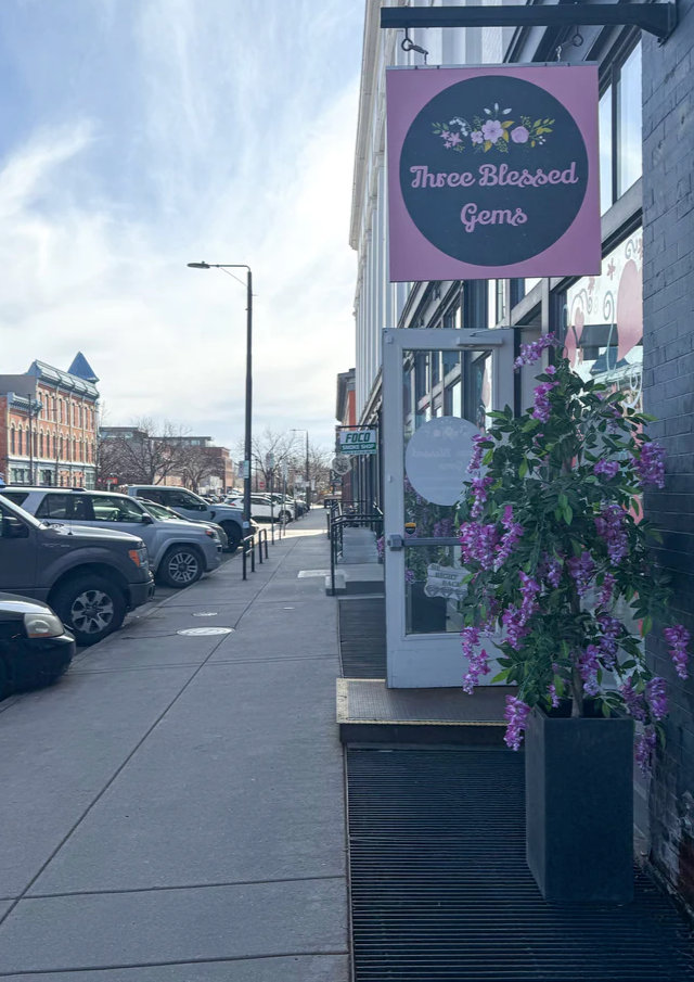 Storefront with 'Three Blessed Gems' sign on a city street
